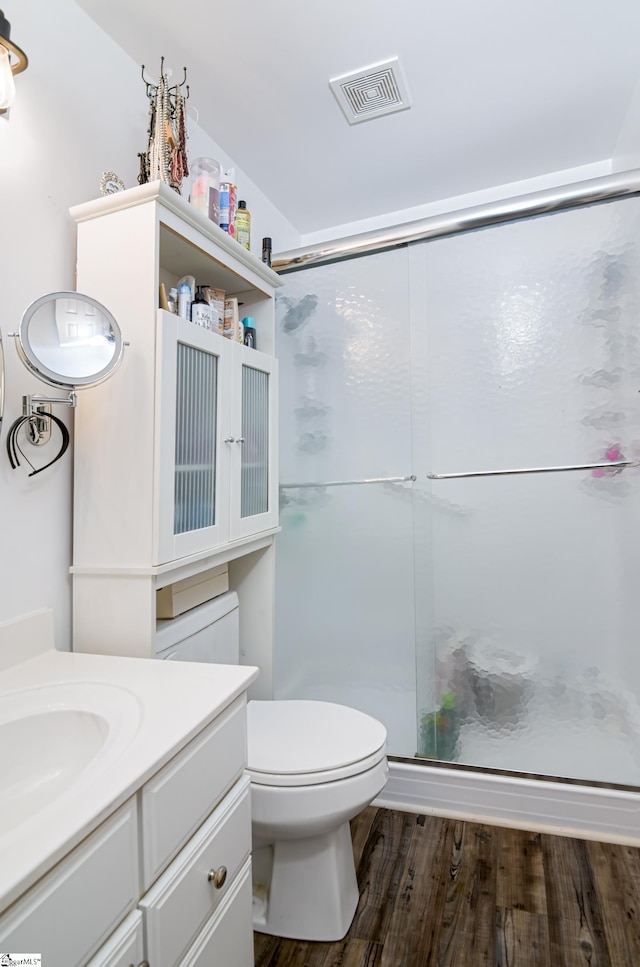 bathroom featuring a shower with shower door, vanity, toilet, and hardwood / wood-style floors