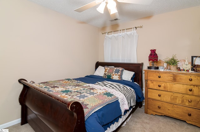 carpeted bedroom featuring ceiling fan and a textured ceiling