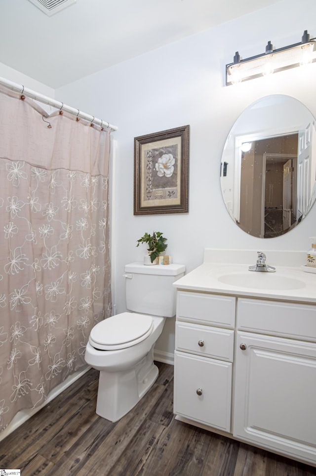 bathroom featuring toilet, walk in shower, hardwood / wood-style floors, and vanity