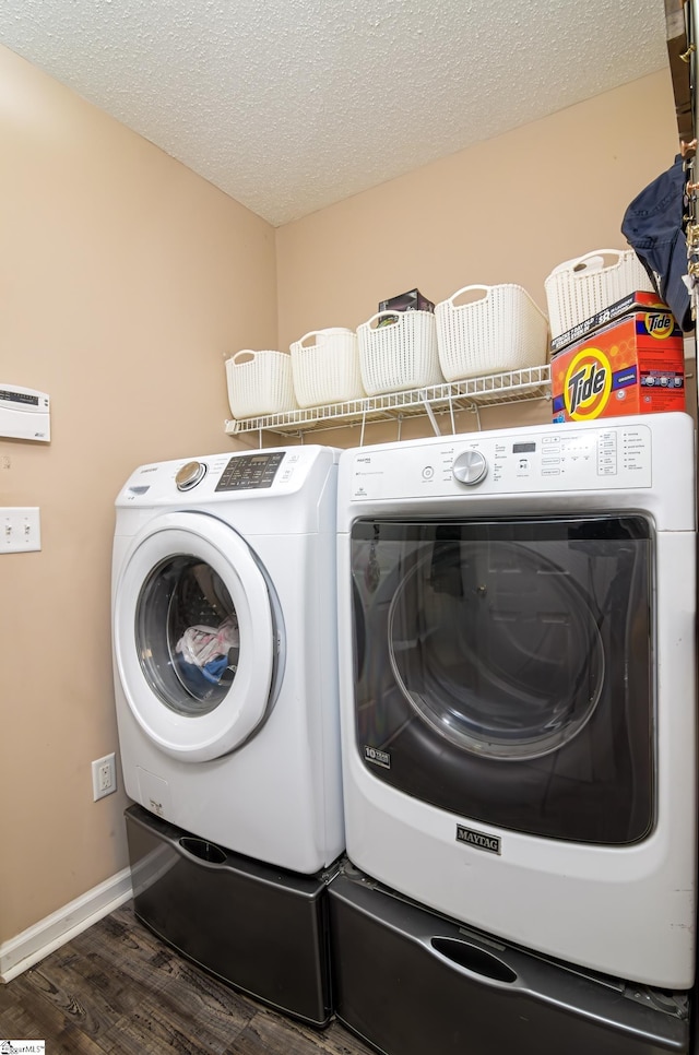 washroom featuring washing machine and dryer, a textured ceiling, and dark hardwood / wood-style floors