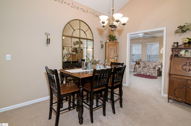 carpeted dining space with lofted ceiling and ceiling fan with notable chandelier