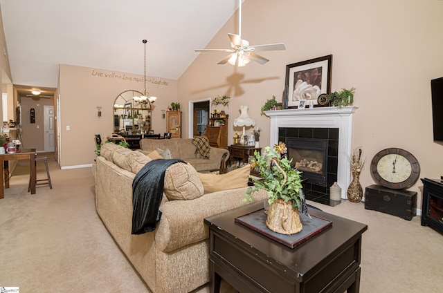 living room with light carpet, a fireplace, ceiling fan with notable chandelier, and high vaulted ceiling