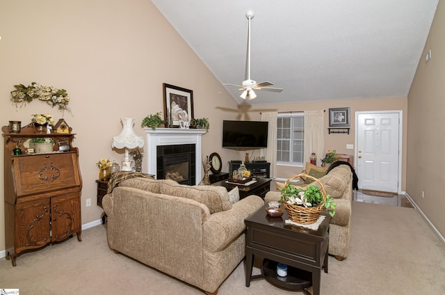 living room with ceiling fan, light carpet, vaulted ceiling, and a tile fireplace