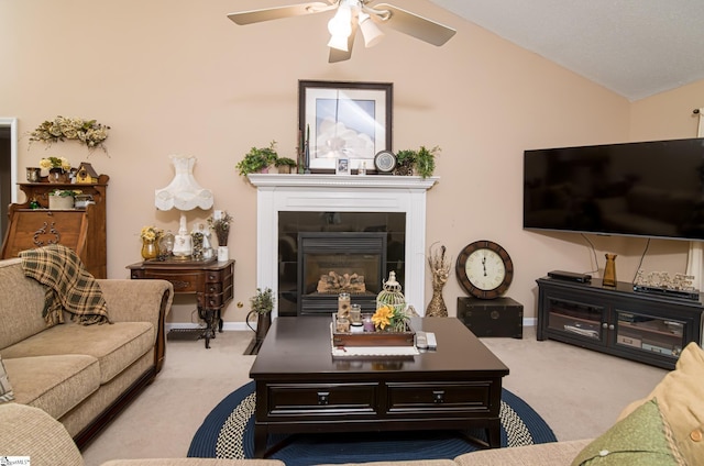 carpeted living room with vaulted ceiling, ceiling fan, and a tiled fireplace