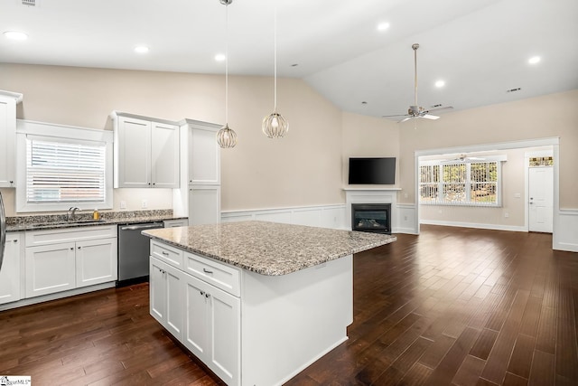 kitchen with lofted ceiling, dishwasher, pendant lighting, sink, and white cabinetry