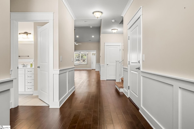 hallway with hardwood / wood-style floors and ornamental molding