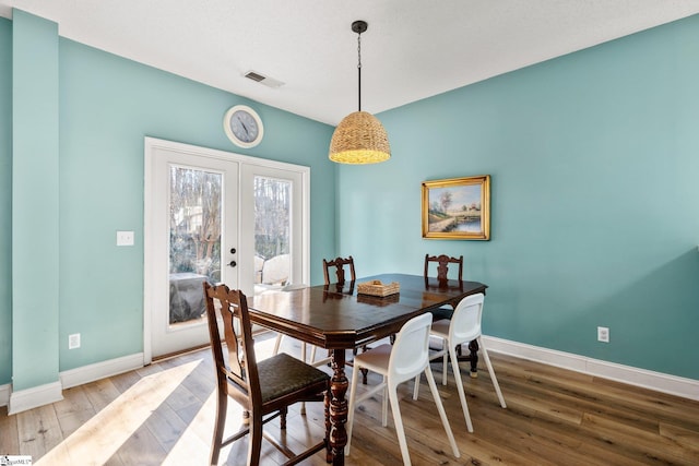 dining area featuring wood-type flooring and french doors