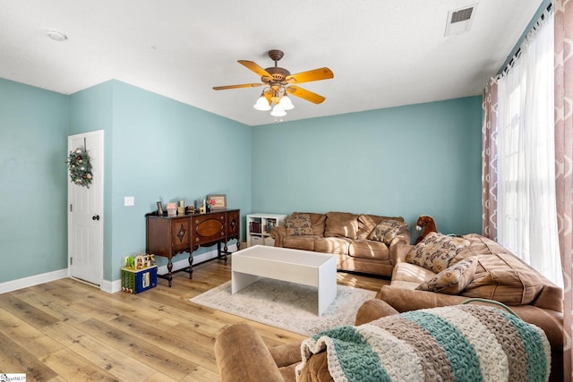 living room featuring ceiling fan, plenty of natural light, and light hardwood / wood-style flooring