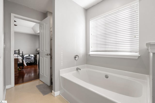 bathroom with a textured ceiling and a tub to relax in