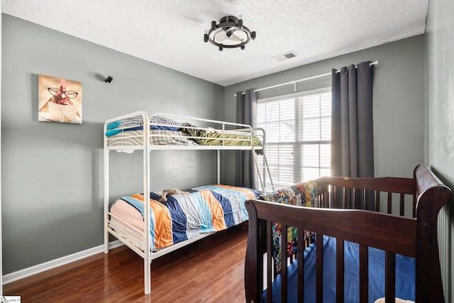 bedroom featuring hardwood / wood-style flooring and a textured ceiling