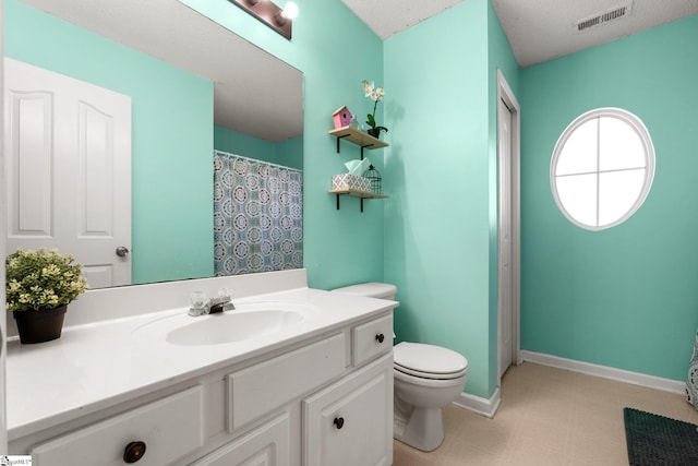 bathroom with toilet, vanity, and a textured ceiling