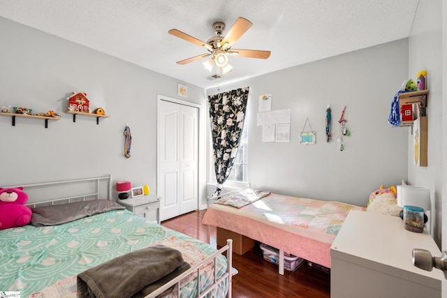 bedroom featuring a textured ceiling, ceiling fan, a closet, and dark hardwood / wood-style floors