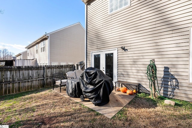 rear view of property featuring a patio area, a lawn, and french doors