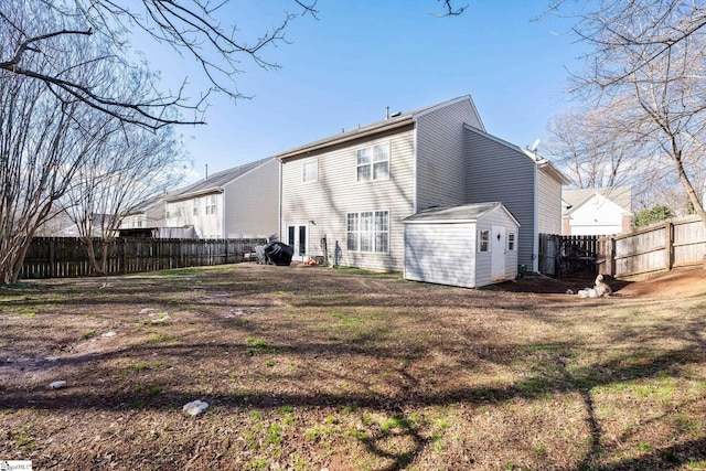 back of property with a shed and a yard