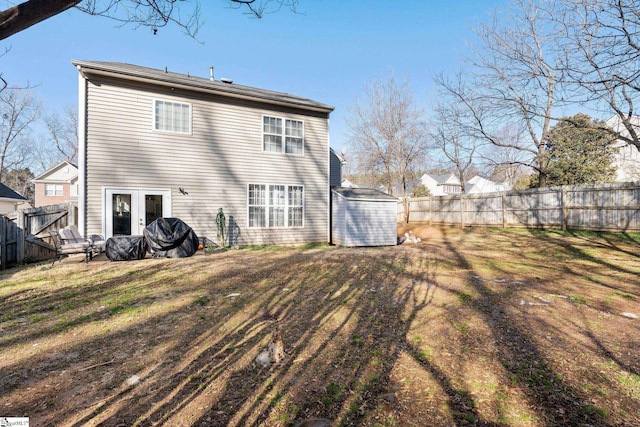 rear view of property featuring a yard, french doors, and a shed