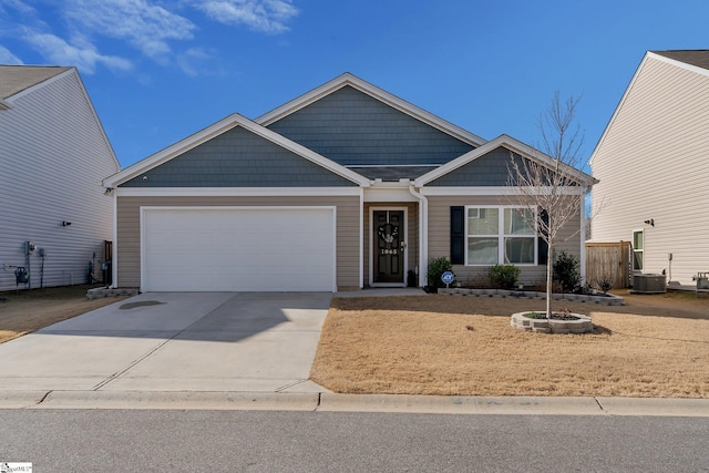 view of front of property featuring a garage and central AC