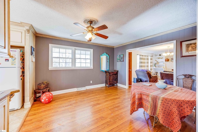 bedroom with white fridge, light hardwood / wood-style flooring, a textured ceiling, ornamental molding, and ceiling fan with notable chandelier