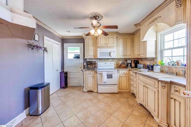 kitchen featuring ceiling fan, white appliances, light tile patterned floors, and crown molding