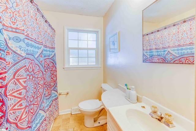 bathroom with toilet, vanity, and a textured ceiling