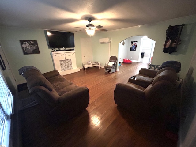 living room with ceiling fan, hardwood / wood-style floors, and a wall mounted air conditioner