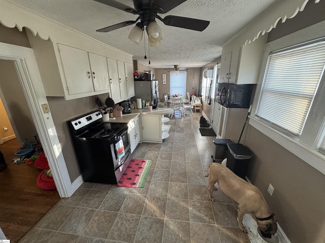 kitchen featuring ceiling fan, appliances with stainless steel finishes, white cabinetry, and a textured ceiling