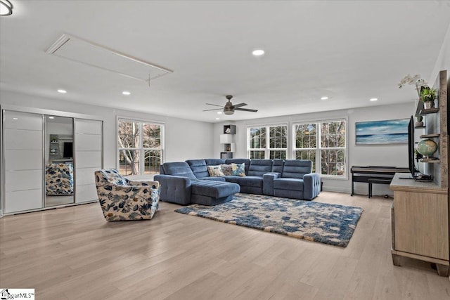 living room with ceiling fan and light hardwood / wood-style flooring