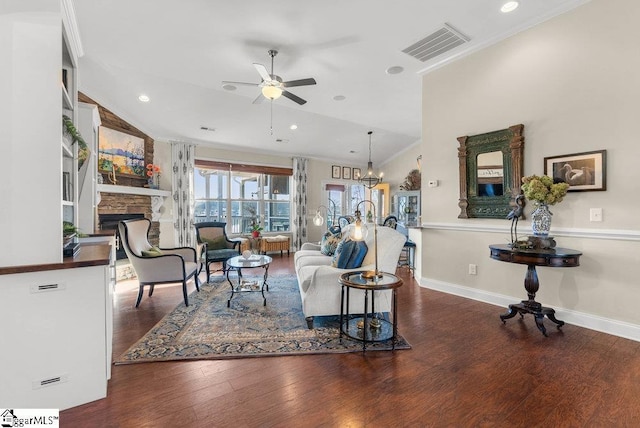 living room featuring ceiling fan, dark hardwood / wood-style flooring, lofted ceiling, and a fireplace