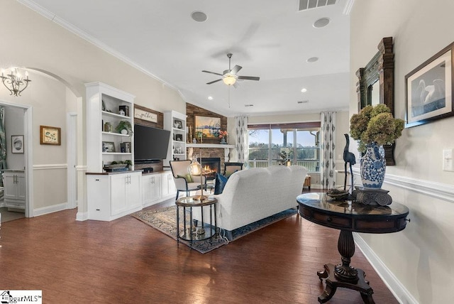 living room featuring ceiling fan, dark hardwood / wood-style flooring, ornamental molding, and a fireplace