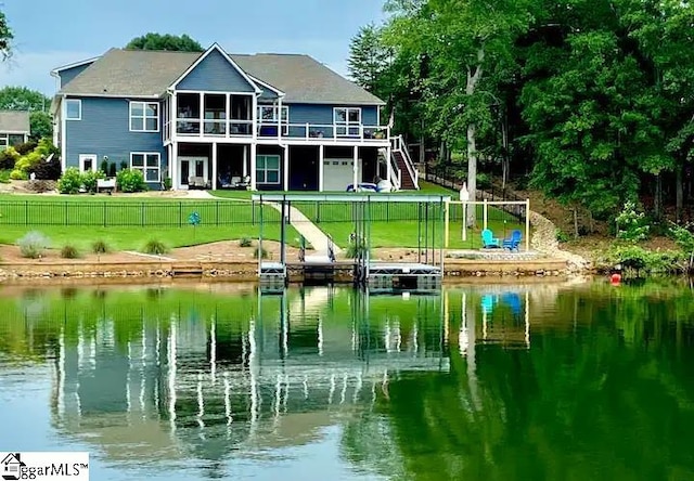 exterior space with a deck with water view and a lawn