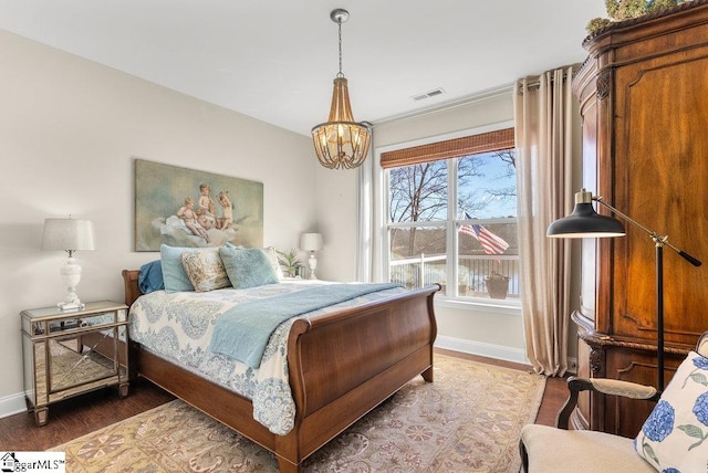 bedroom featuring dark wood-type flooring and a notable chandelier