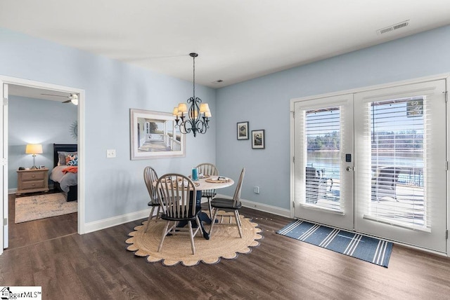 dining area featuring ceiling fan with notable chandelier, dark hardwood / wood-style floors, and french doors