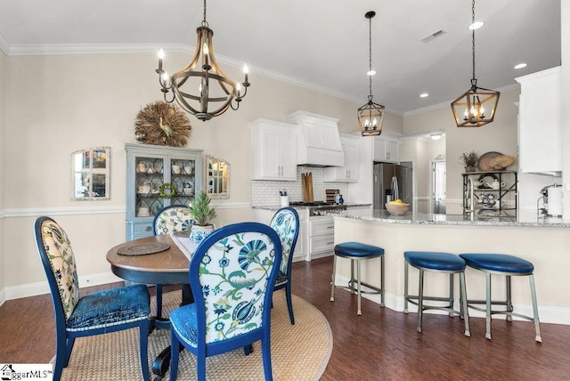 dining room with dark hardwood / wood-style flooring, crown molding, and a chandelier