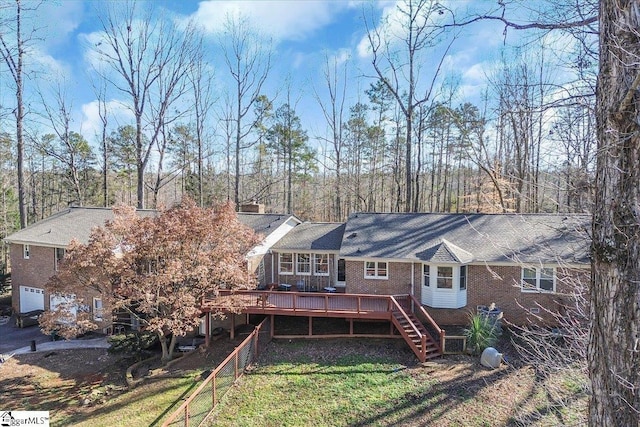 rear view of property featuring brick siding, a deck, and stairs