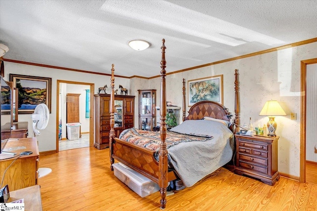 bedroom with light wood-style floors, ornamental molding, a textured ceiling, and wallpapered walls