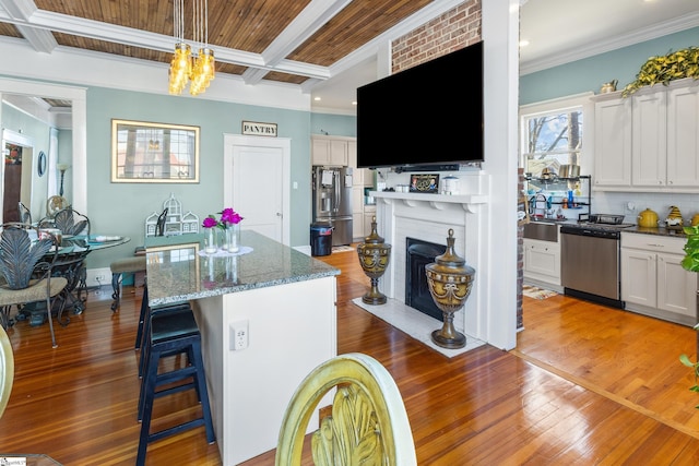 kitchen featuring white cabinets, a center island, stainless steel appliances, and coffered ceiling