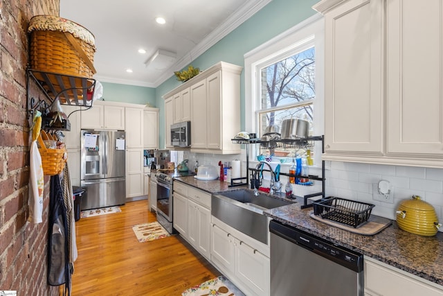 kitchen with white cabinets, dark stone counters, sink, and stainless steel appliances