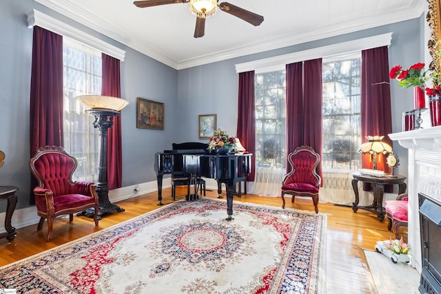 living area featuring hardwood / wood-style flooring, crown molding, and ceiling fan