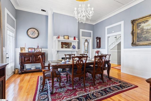 dining room with an inviting chandelier, ornamental molding, and wood-type flooring