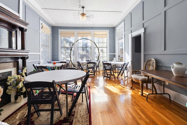 dining space with ceiling fan, wood-type flooring, and crown molding