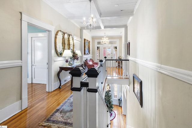 corridor with french doors, ornamental molding, beam ceiling, and hardwood / wood-style flooring