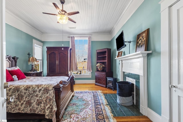 bedroom with ceiling fan, light wood-type flooring, ornamental molding, and multiple windows