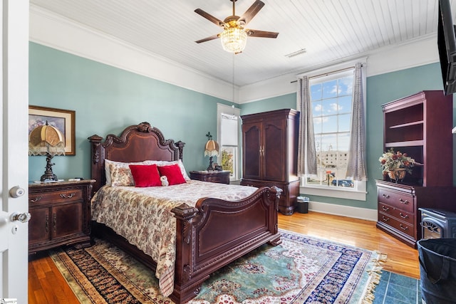 bedroom with ceiling fan, crown molding, and light hardwood / wood-style flooring