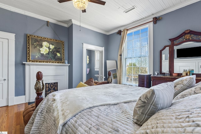 bedroom with ceiling fan, ornamental molding, and hardwood / wood-style flooring