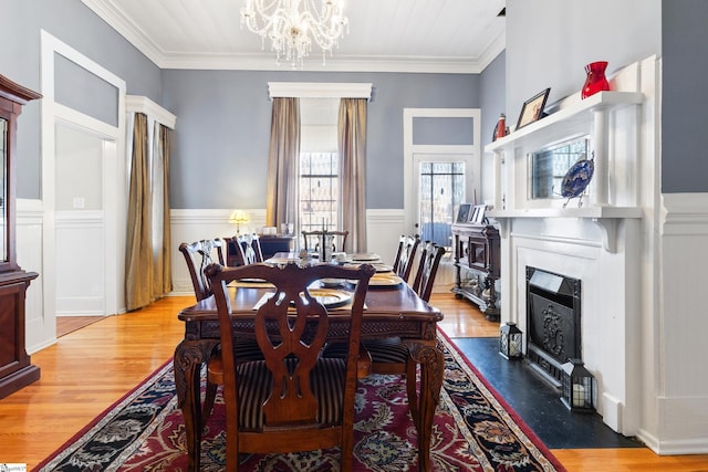 dining space featuring ornamental molding, hardwood / wood-style flooring, and a notable chandelier