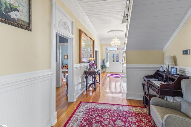 hallway with light hardwood / wood-style flooring and a chandelier