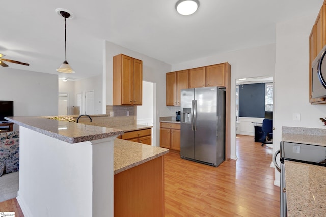 kitchen featuring pendant lighting, kitchen peninsula, stainless steel refrigerator with ice dispenser, light wood-type flooring, and electric stove