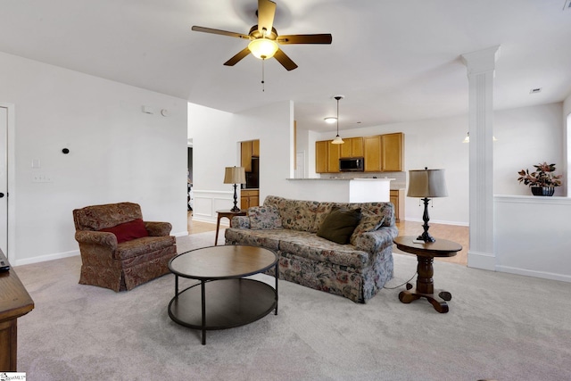 living room with ceiling fan, light colored carpet, and decorative columns