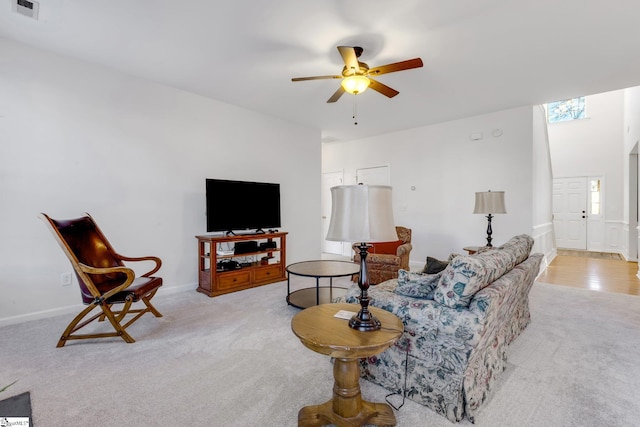 carpeted living room with ceiling fan