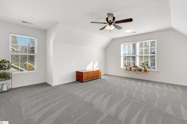 bonus room with lofted ceiling, plenty of natural light, and carpet flooring