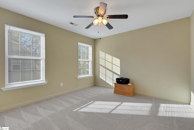 carpeted spare room with ceiling fan